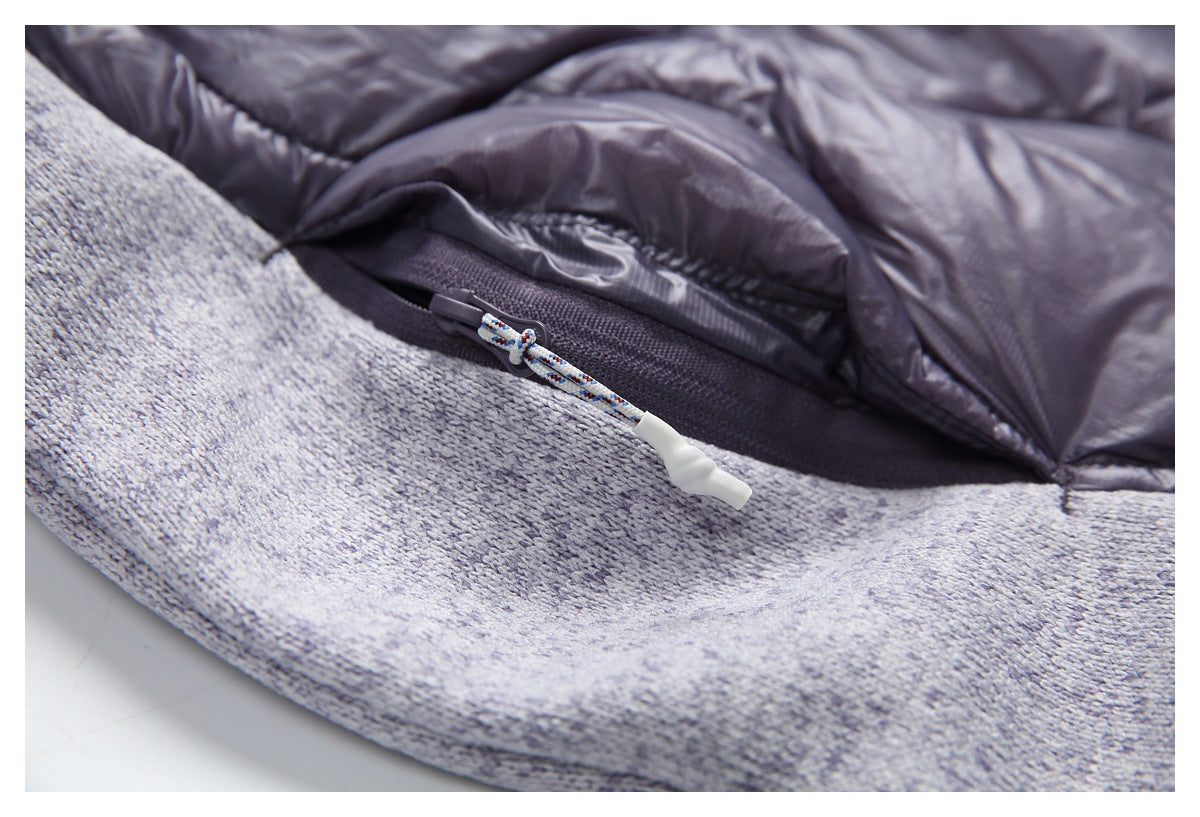 Close-up of a zipper with a patterned cord pull on the jacket’s gray knit and plum quilted fabric.