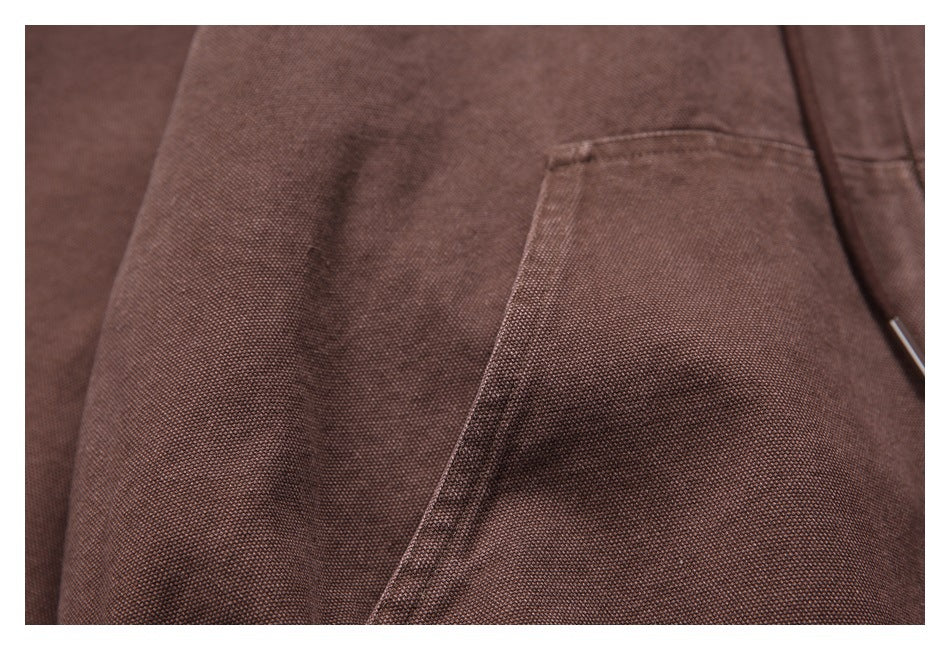 Close-up showing the brown hoodie’s textured fabric and kangaroo pocket stitching.