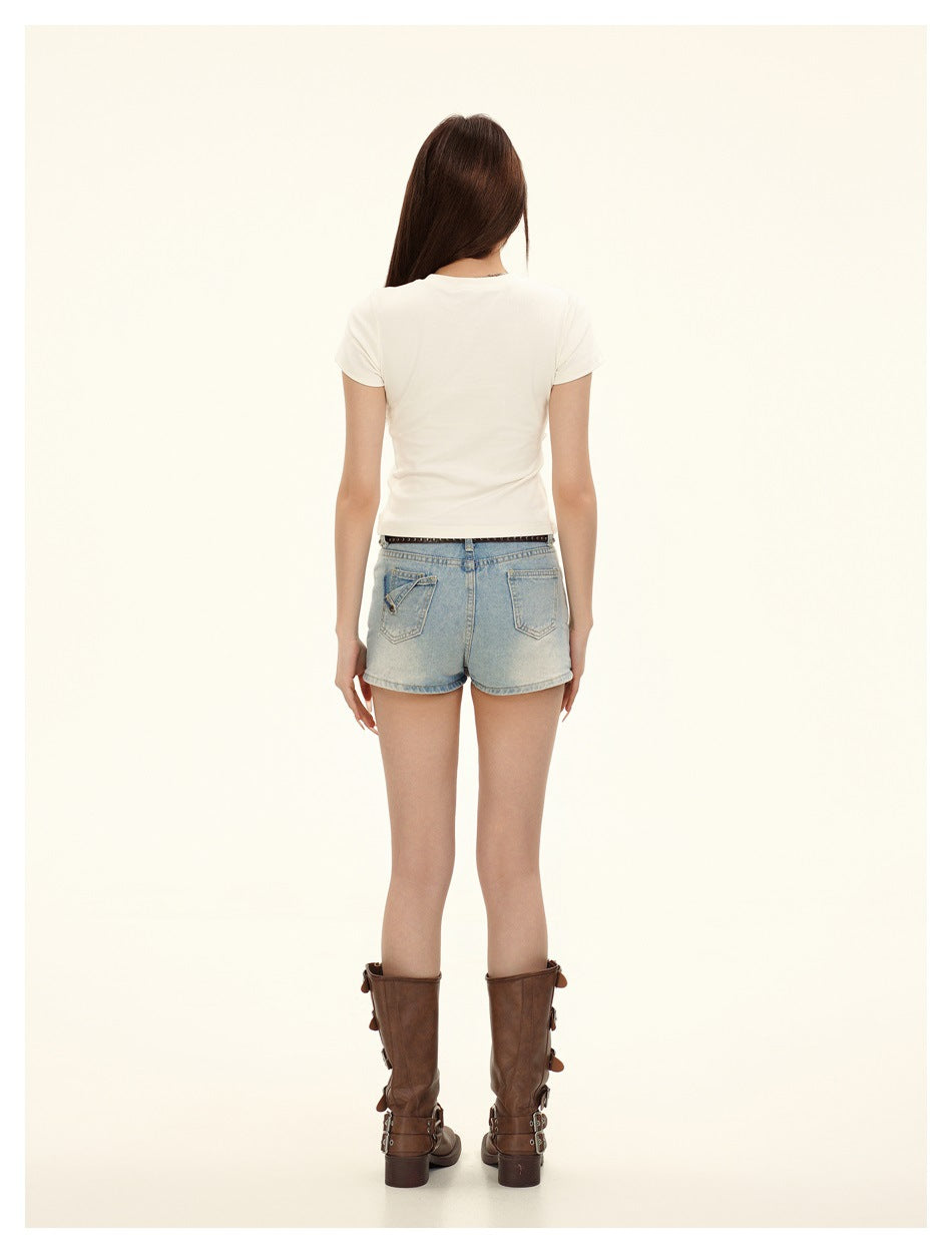 Back view of a model wearing a plain white fitted T-shirt and light-wash denim shorts.