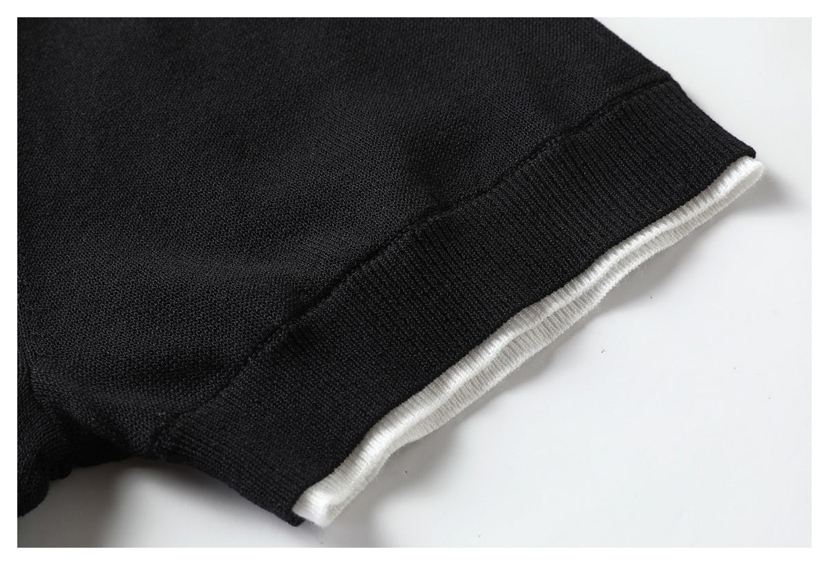 Close-up of black knit fabric with a ribbed edge and narrow white trim.