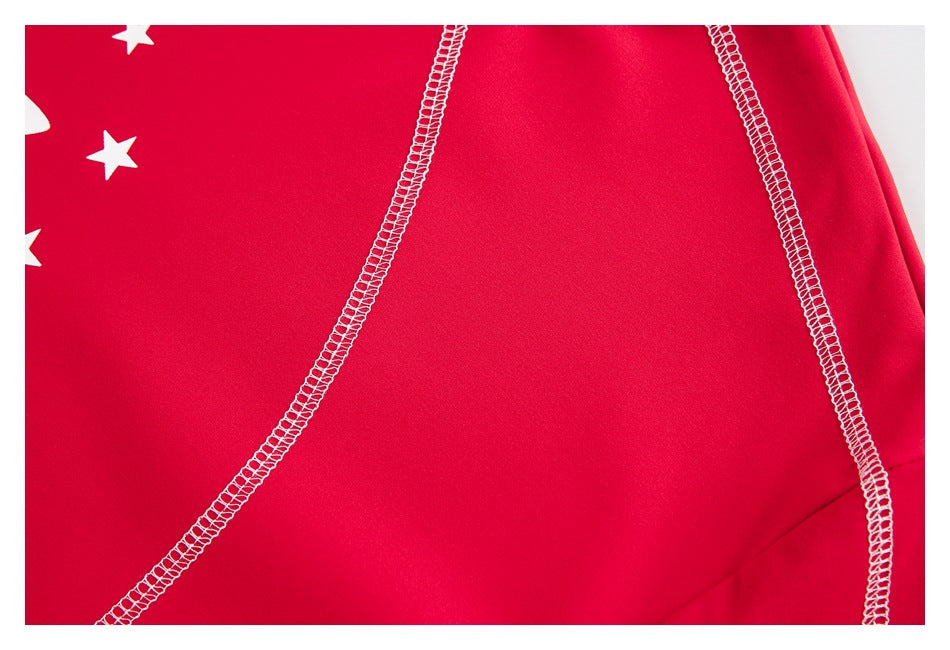 Close-up of bright red shirt fabric with curved white overlock seams and part of a white star print.