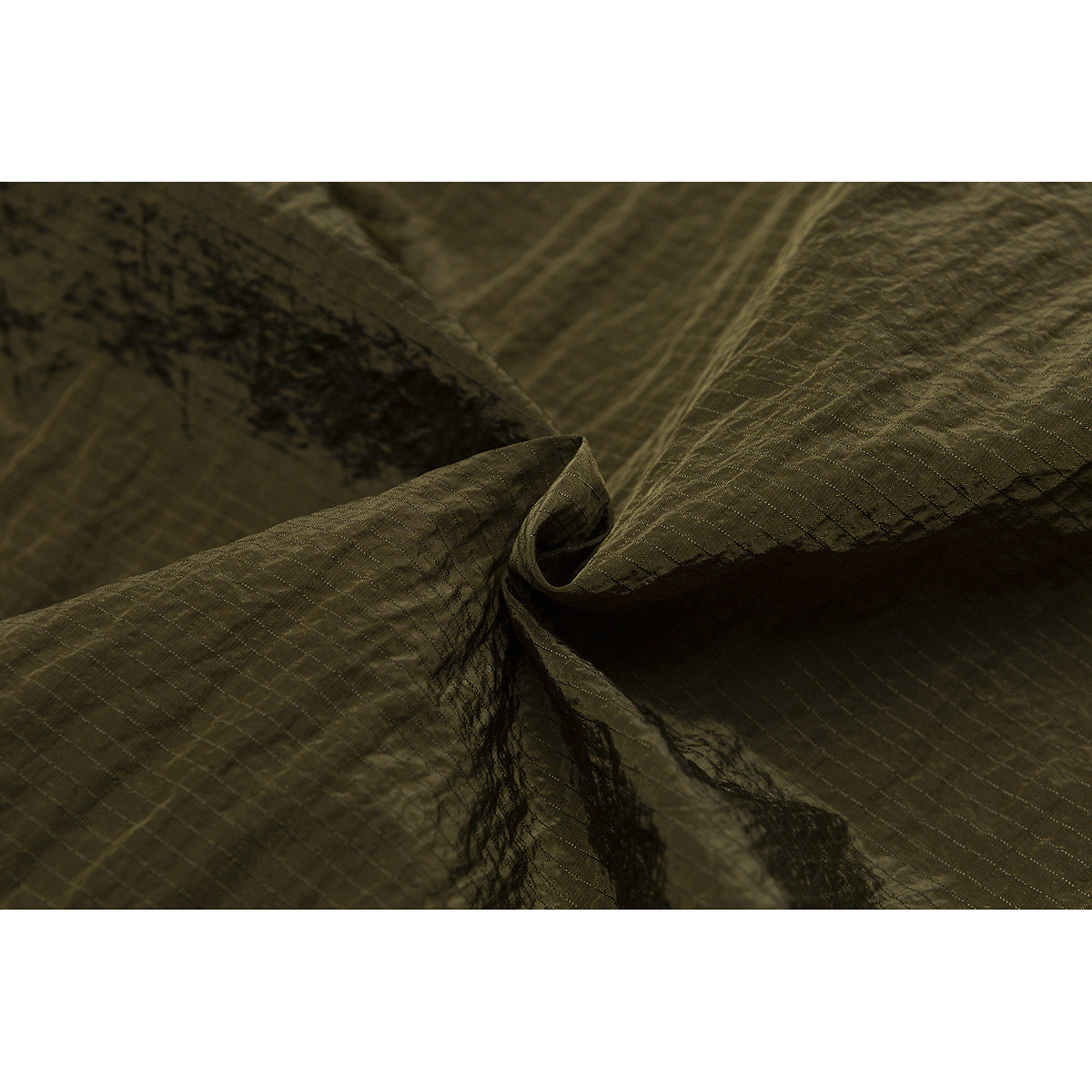 Close-up of olive fabric gathered to show its subtle grid texture and sheen.