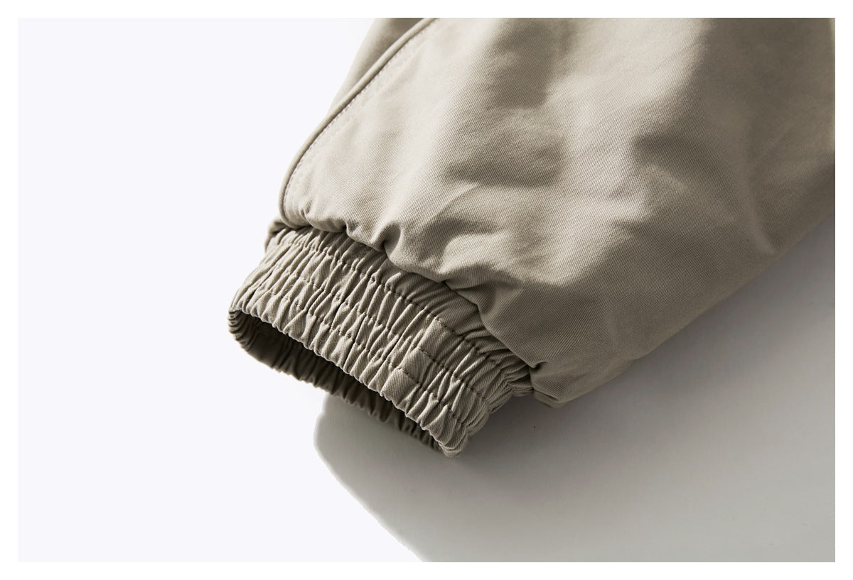 Close-up of a beige jacket sleeve with a gathered elastic cuff.