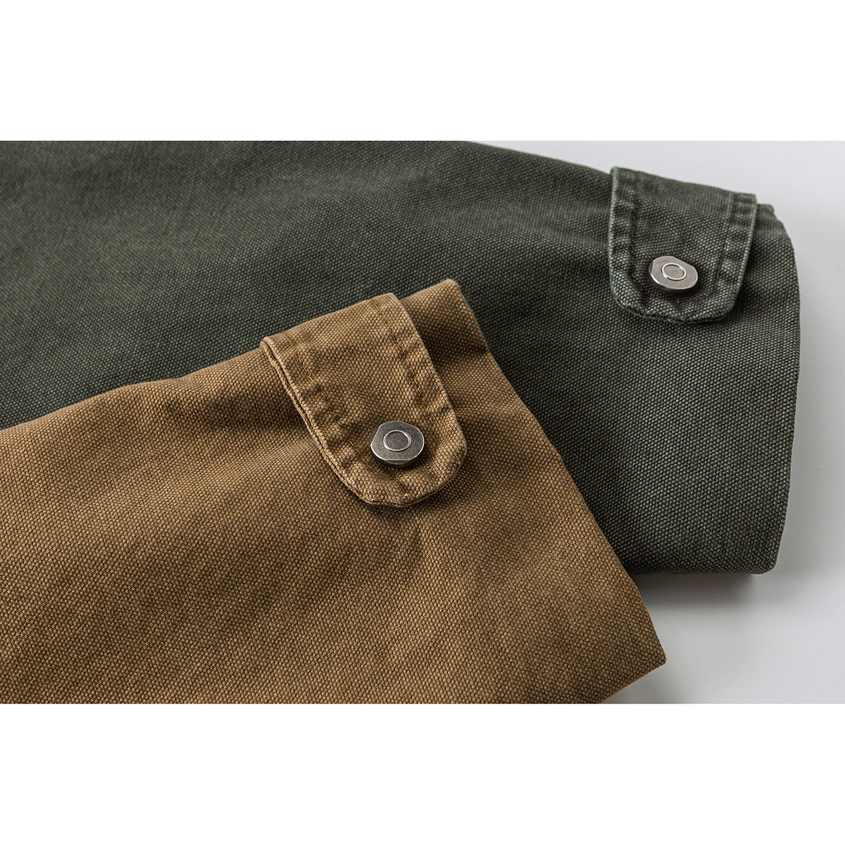 Close-up of snap-tab cuffs on dark olive and brown jackets.