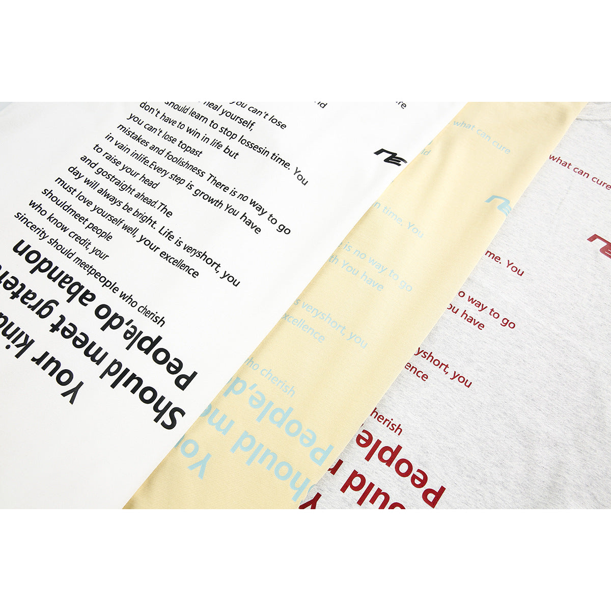 Close-up of white, pale yellow, and light gray shirt fabric with printed English text and small graphics.