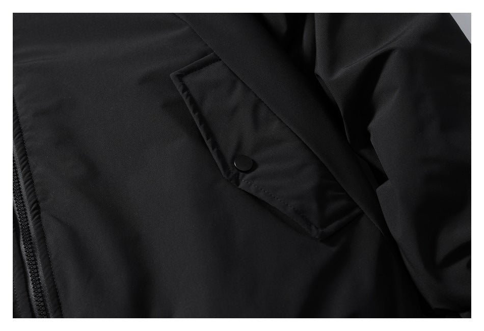 Close-up of a black jacket pocket with a snap closure beside the front zipper.