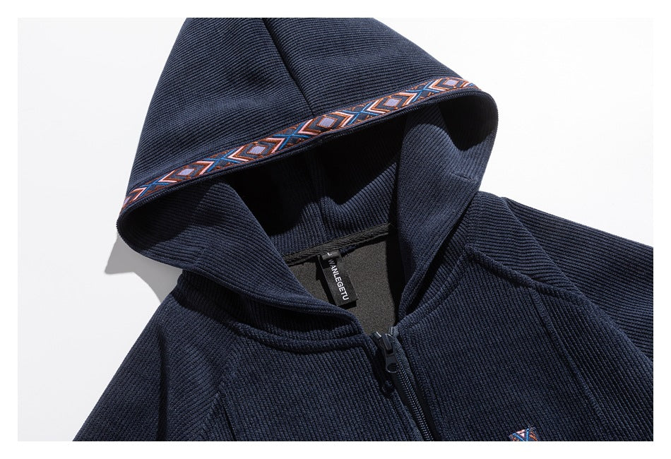 Close-up of a navy zip-up hoodie hood with orange, blue and white geometric trim and a visible neck label.