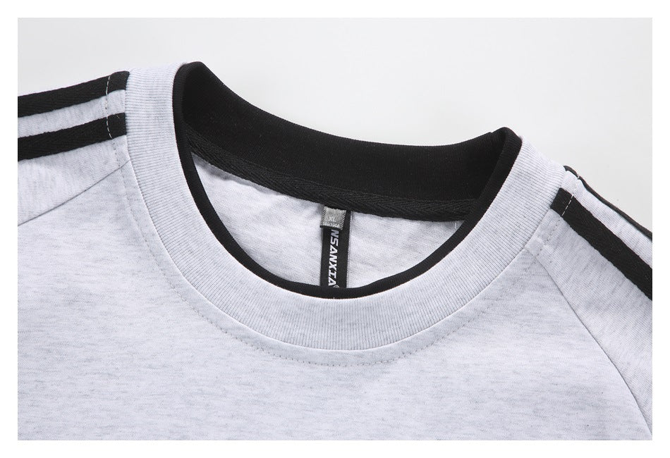 Close-up of the light gray sweatshirt's crew neck, black inner collar, and striped shoulder trim.
