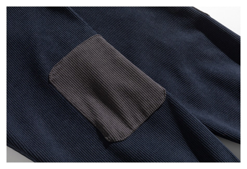 Close-up of dark navy ribbed garment fabric with a rectangular brown patch.
