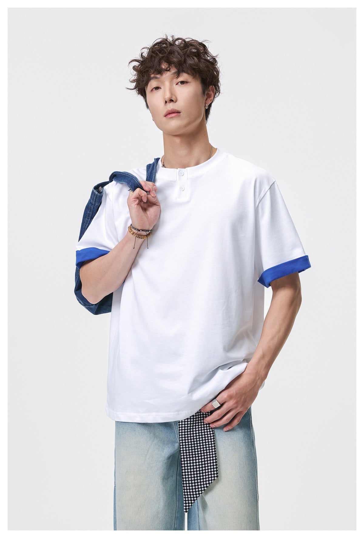 Model wearing a white two-button henley T-shirt with blue rolled cuffs, shown from the front.