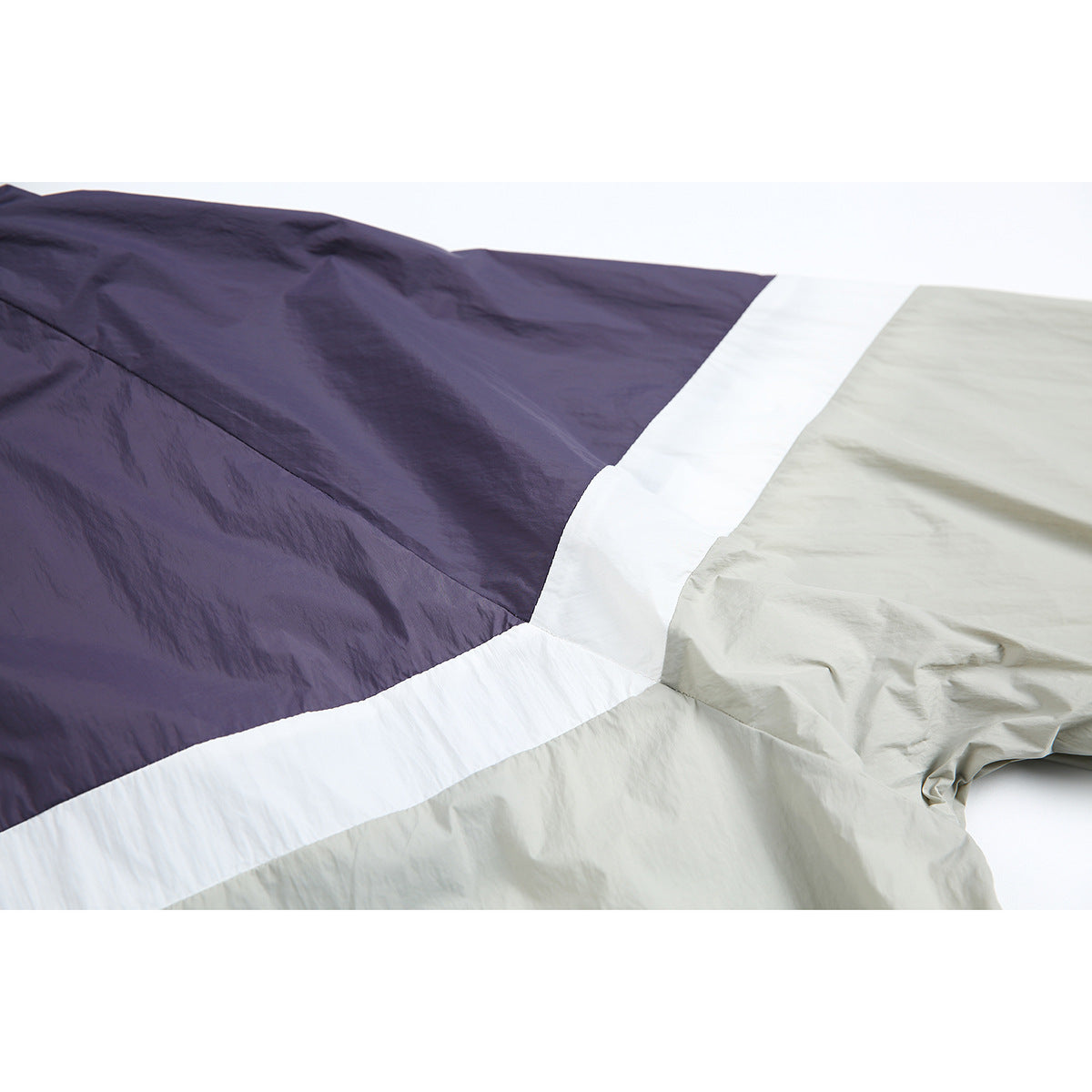 Close-up of the jacket's purple, white, and light gray colorblock panels and fabric.
