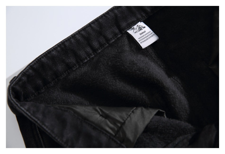 Close-up of black jeans opened to show a soft, dark fleece lining and a small sewn-in label.