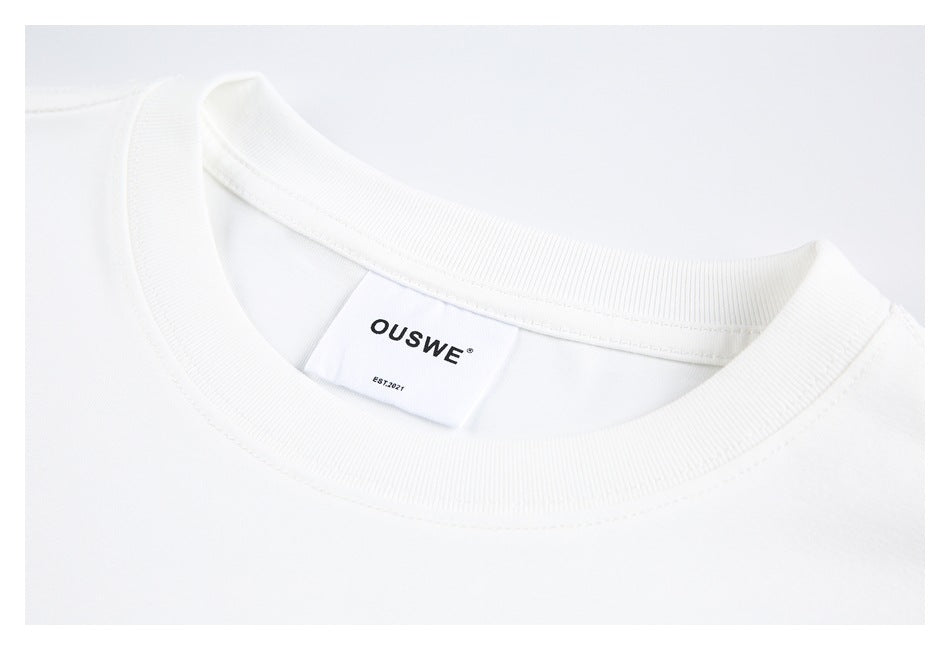 Close-up of the white T-shirt's ribbed crew neck and sewn-in OUSWE brand label.