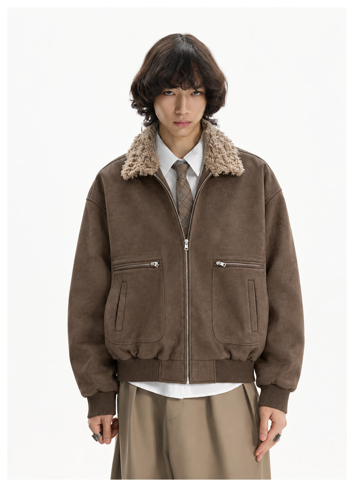 Model wearing brown zip-up jacket with tan fleece-like collar over a white shirt and tie, front view with zipped pockets