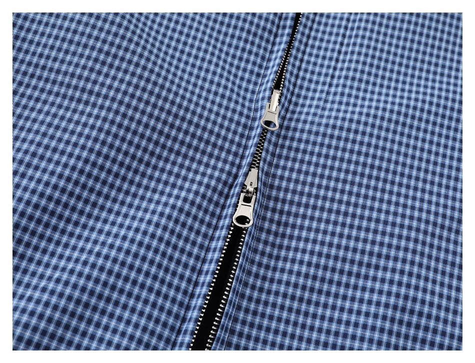 Close-up of the blue checked jacket’s black two-way front zipper and silver pulls.