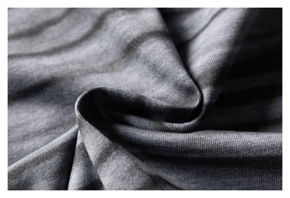 Close-up of gray-and-charcoal striped fabric gathered into folds, showing its surface and drape.