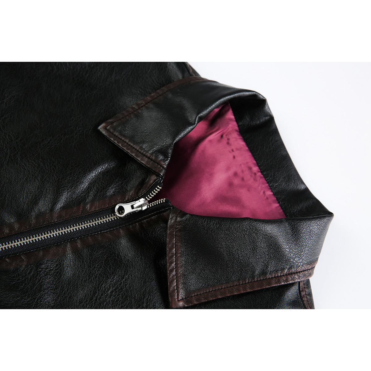 Close-up of a black jacket's notched collar, silver zipper, and magenta lining.