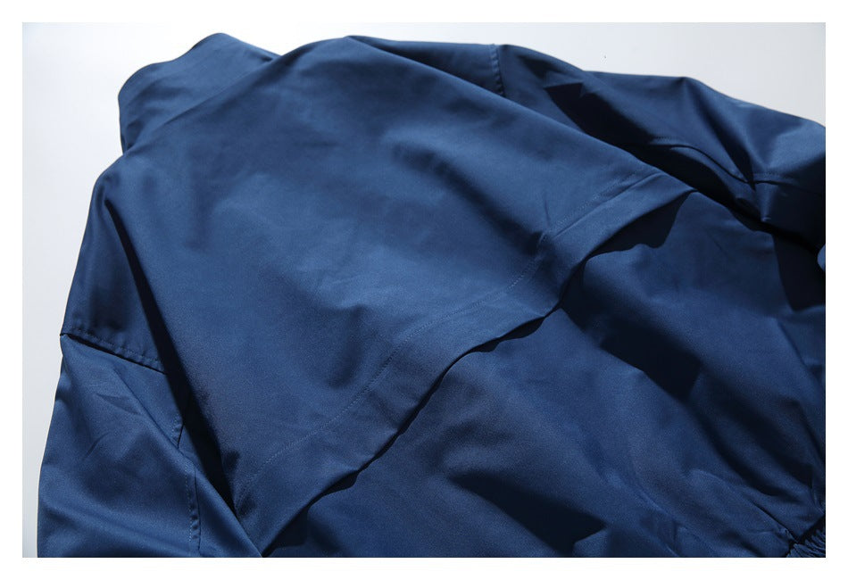 Close-up of the navy garment's overlapping fabric panels and stitched seams.