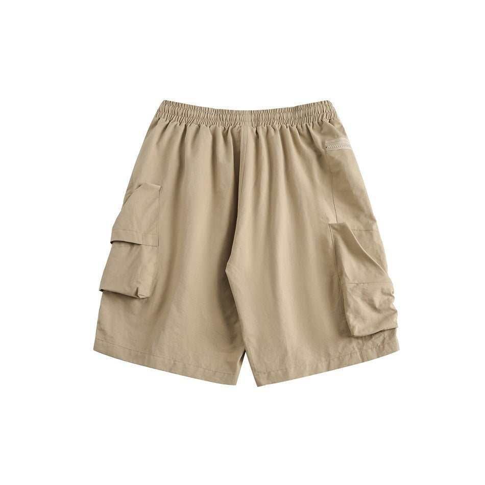 Front view of tan cargo shorts with an elastic waistband and large flap pockets on both sides.