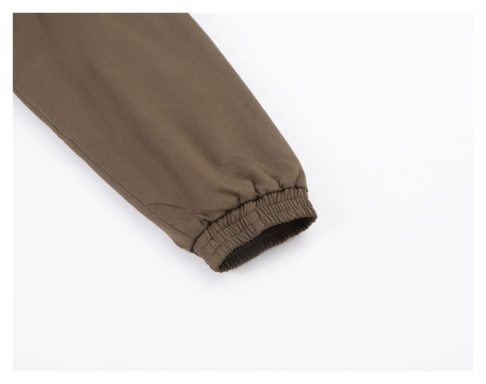 Close-up of a brown jacket sleeve ending in a gathered elastic cuff.