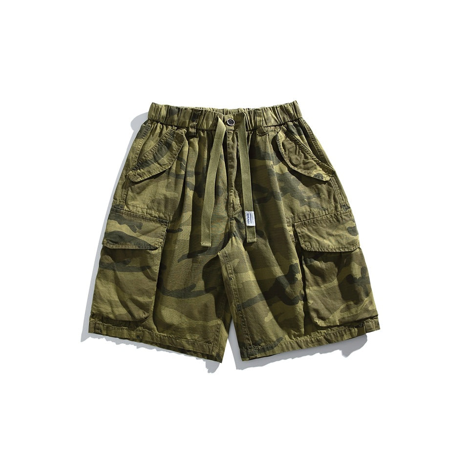 Front view of olive camouflage cargo shorts with an elastic drawstring waist and large flap pockets.