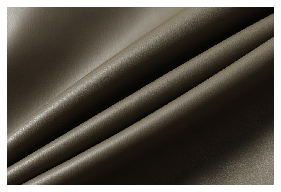 Close-up of olive-brown pebbled material arranged in diagonal folds.