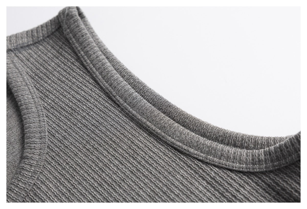 Close-up of the gray top's rounded neckline and textured knit fabric.