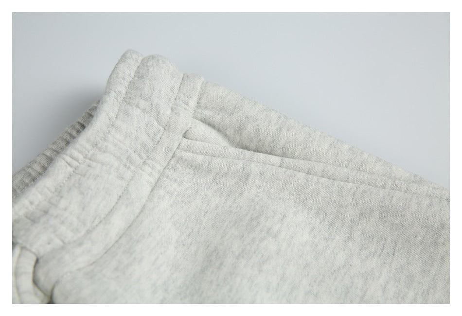 Close-up of light heather gray shorts showing the elastic waistband and slanted side pocket seam.
