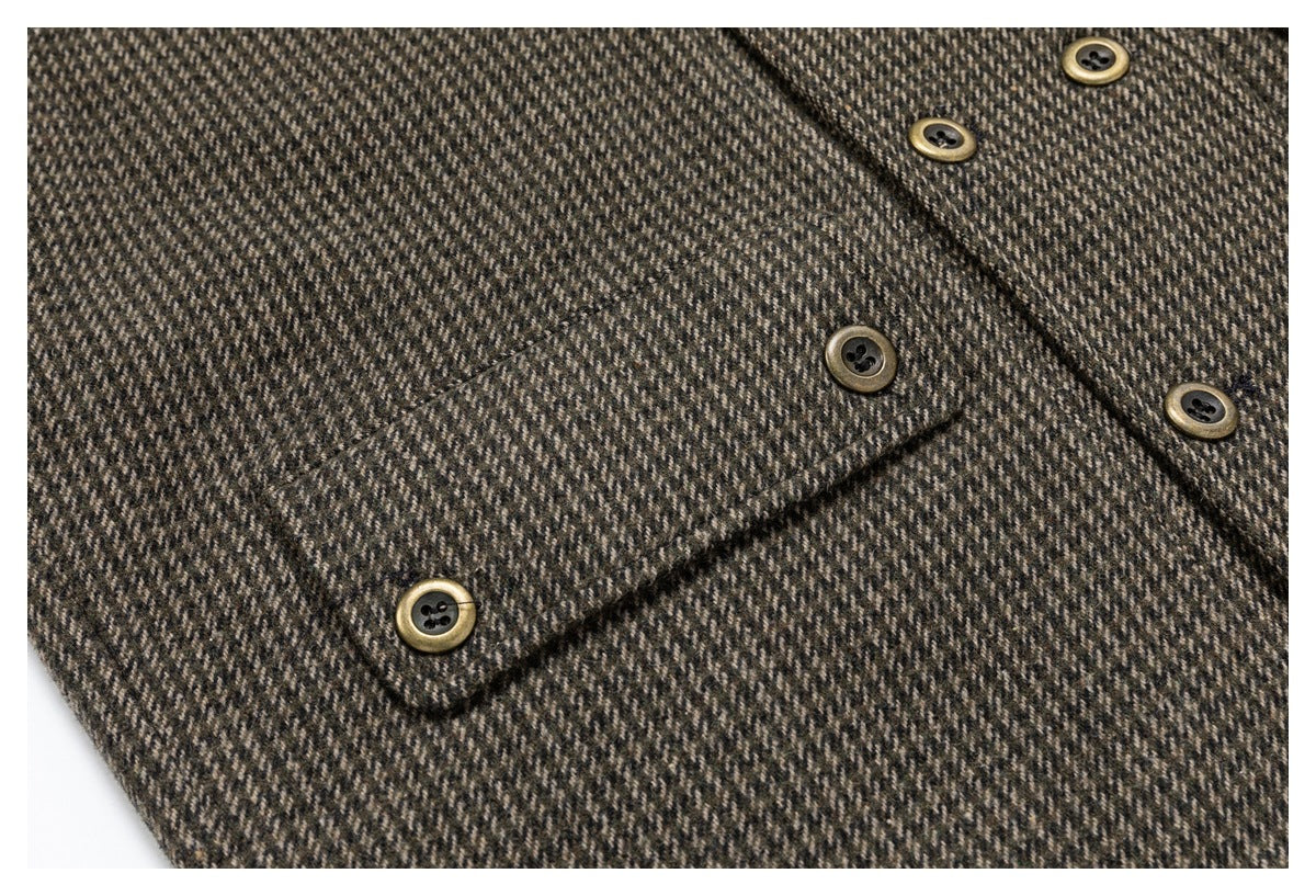 Close-up of a brown and charcoal herringbone jacket showing a flap pocket and antique-gold buttons.