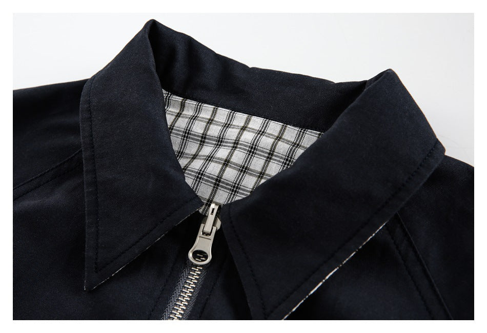 Close-up of the jacket's pointed collar, silver zipper, and black-and-white plaid lining.