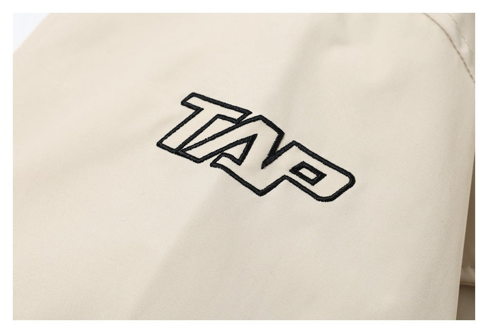 Black outlined lettering embroidered on the cream jacket fabric.