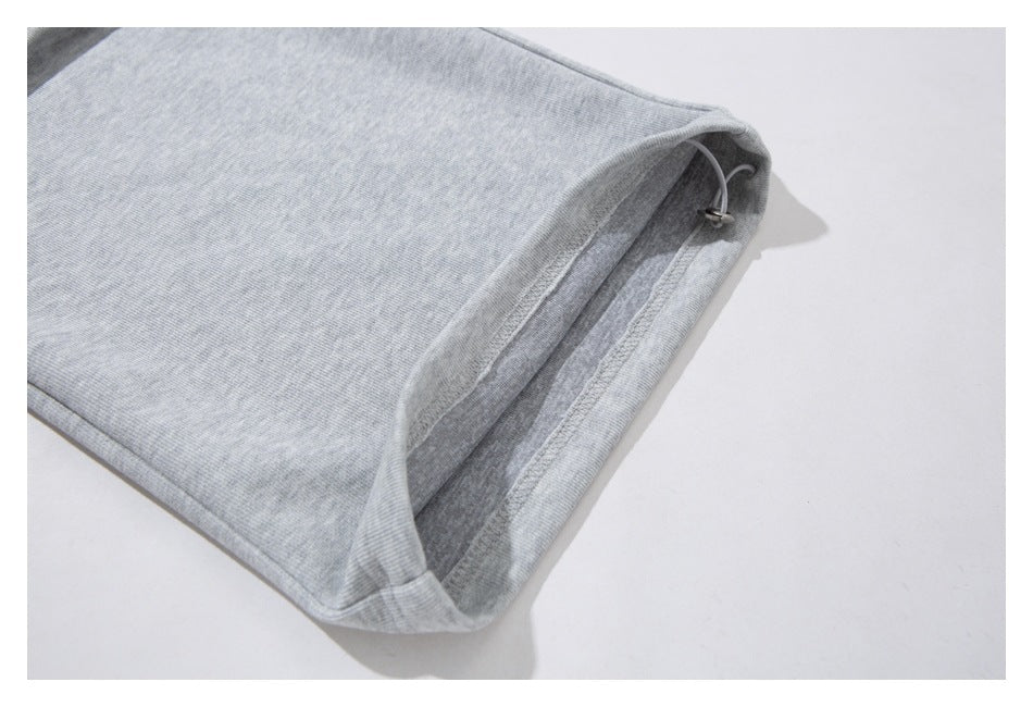 Close-up of the open leg hem of light gray heathered pants with an adjustable drawcord.