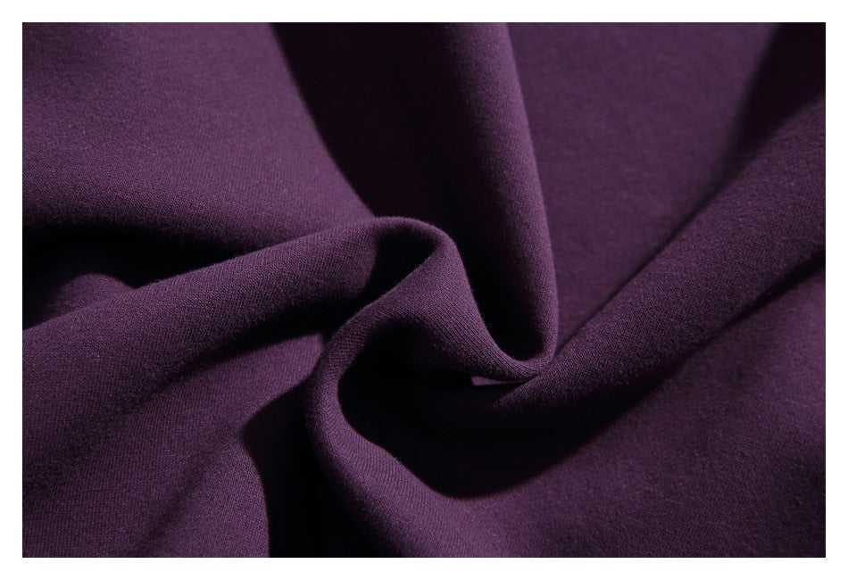 Macro view of dark purple garment fabric gathered into soft folds.