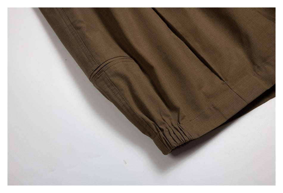 Close-up of brown trousers showing an elasticized hem, stitching, and part of a pocket.