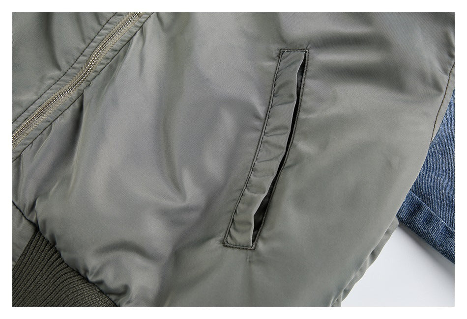 Close-up of a gray bomber jacket's narrow side pocket and ribbed hem.