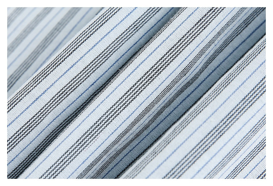 Macro view of white fabric with repeating fine blue and black striped lines.