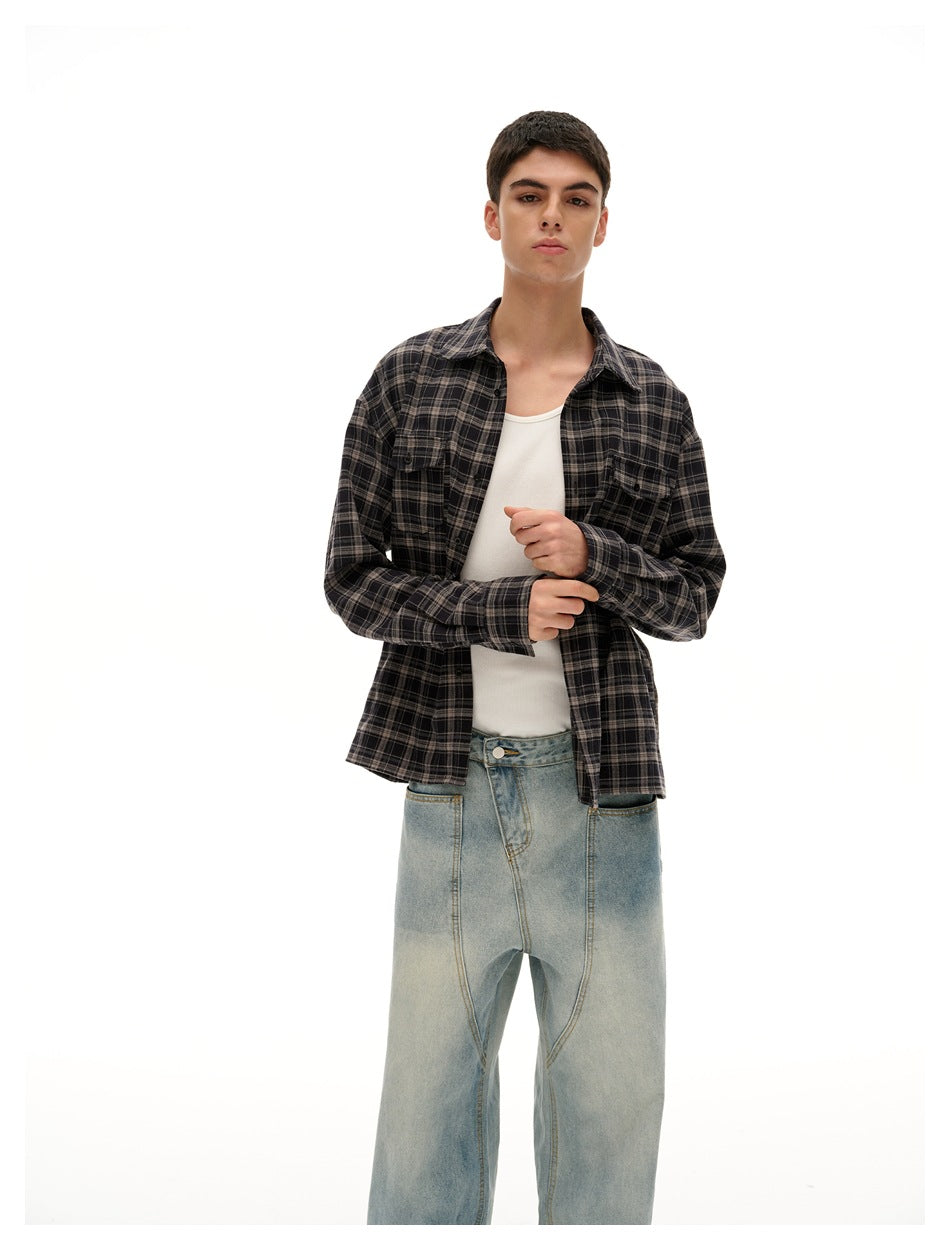 Model wearing a dark charcoal plaid button-up over a white tank and light-wash wide-leg jeans.