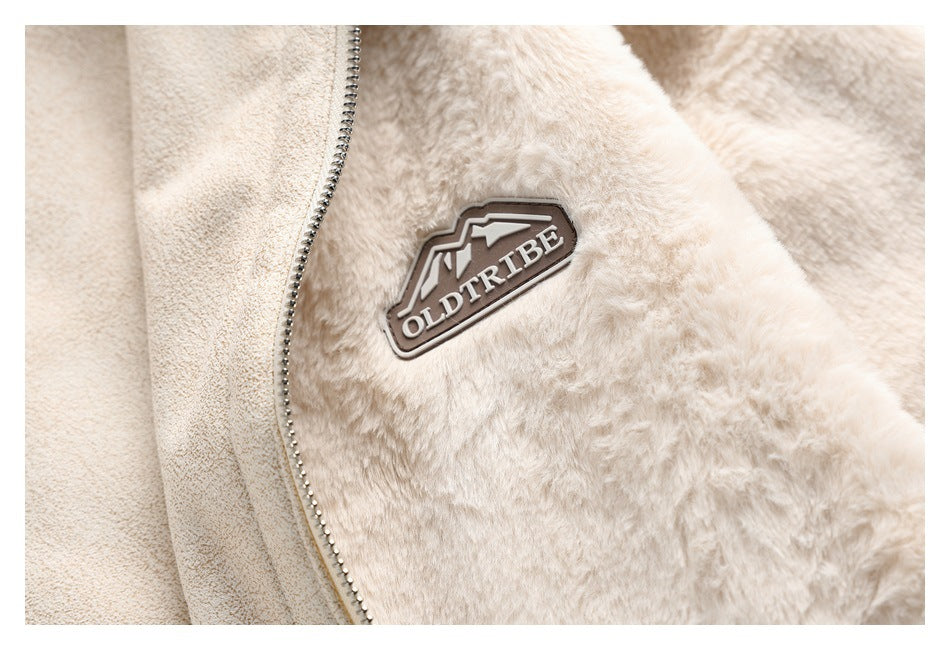 Close-up of the OLDTRIBE patch beside the zipper on an ivory faux-fur jacket.