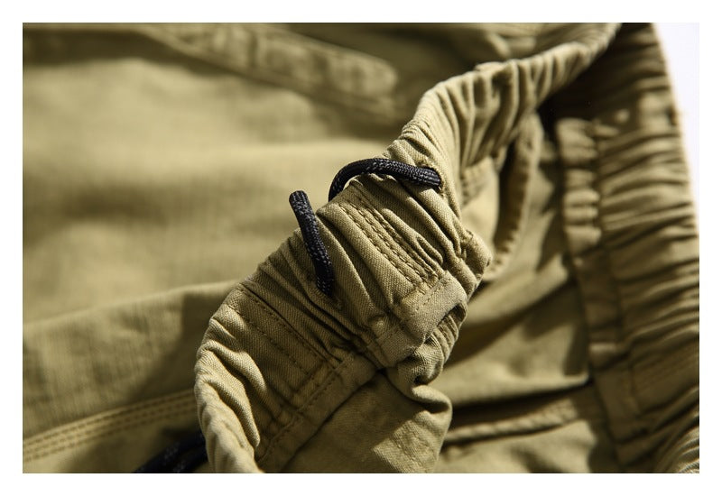 Close-up of the gathered khaki shorts waistband with black drawcords and reinforced stitching.