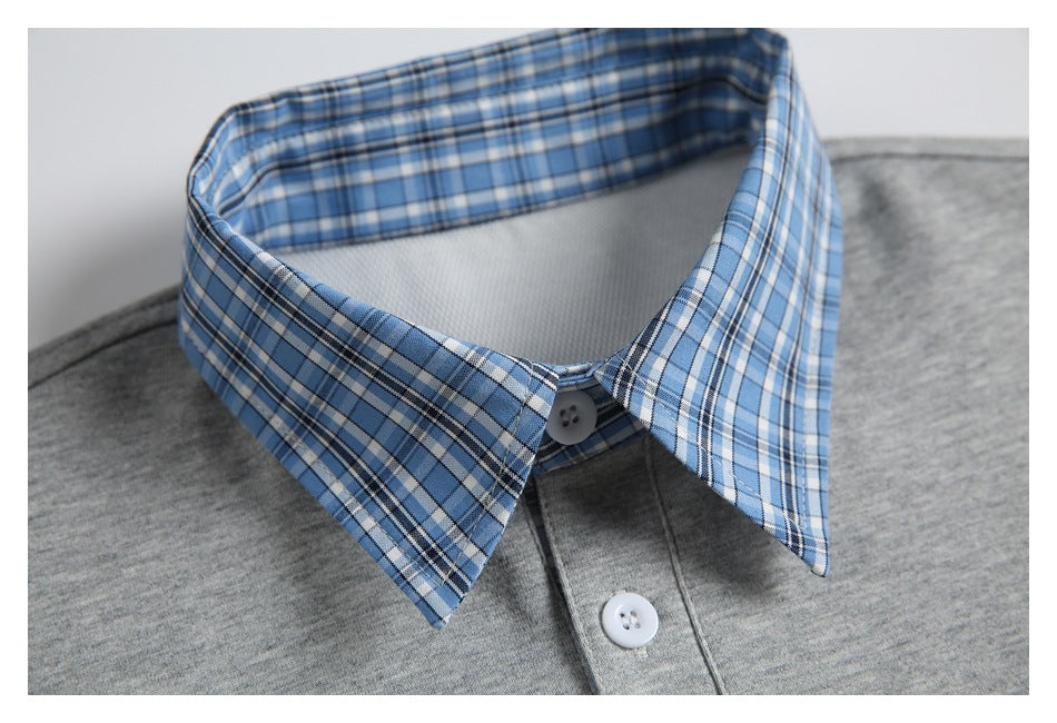Close-up of a blue plaid pointed collar and white-button placket on a heather gray polo.