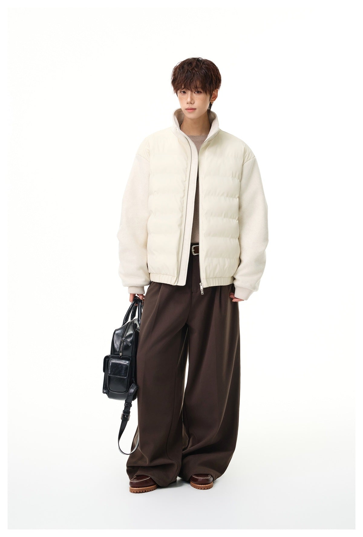 Full-length view of a model wearing an ivory hybrid jacket with a quilted front, textured sleeves, and a high collar.