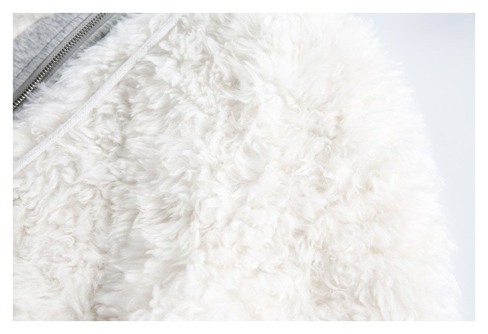Close-up of the jacket's white shaggy surface, with a white drawstring and part of the gray zipper trim.