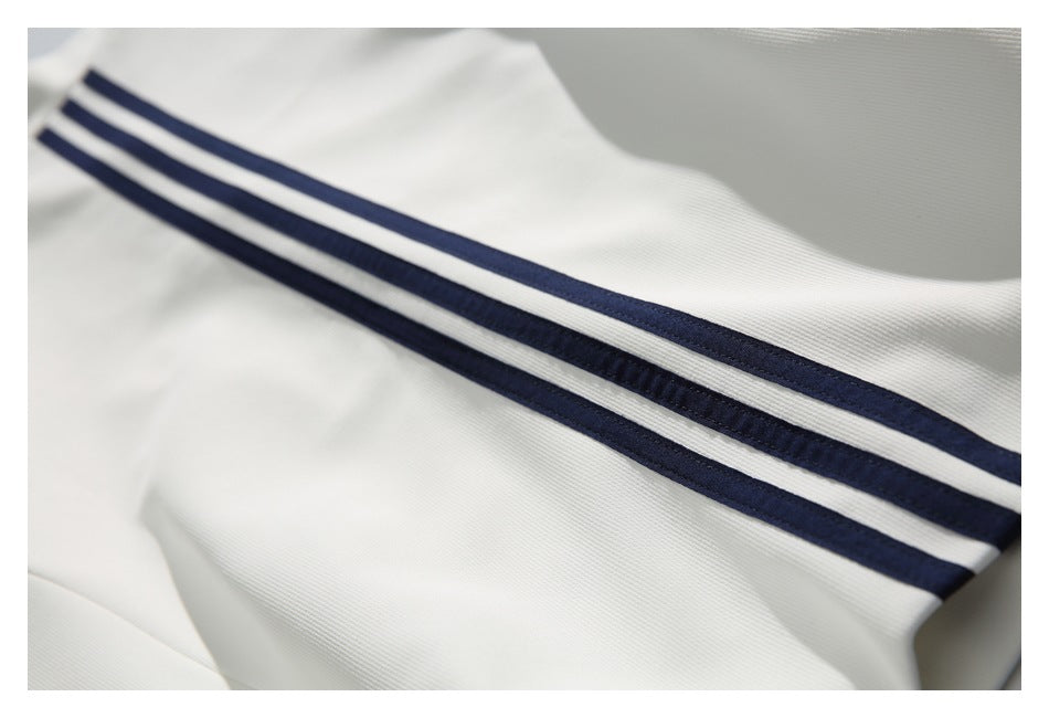 Close-up of white garment fabric with two parallel navy stripes.