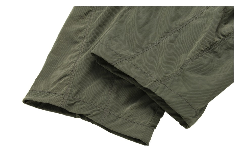 Close-up of the olive shorts' stitched leg hems.
