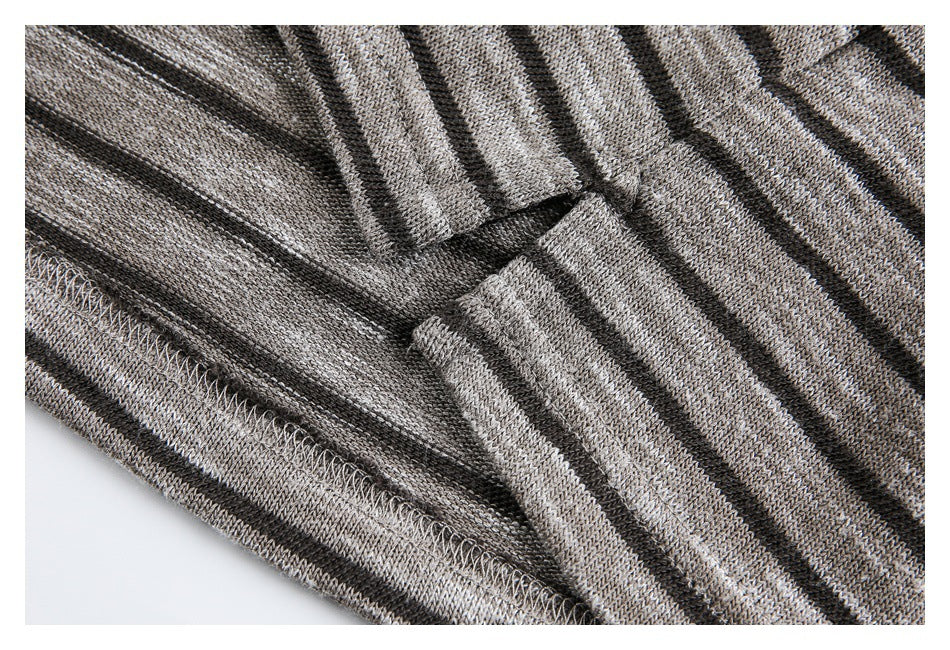 Close-up of the overlocked hem seam on a gray and black striped knit garment.