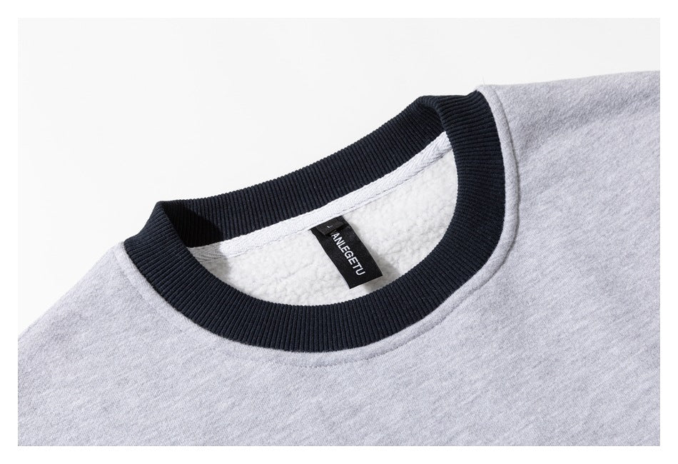 Close-up of a light gray sweatshirt neckline with a black ribbed collar and a visible black neck label.