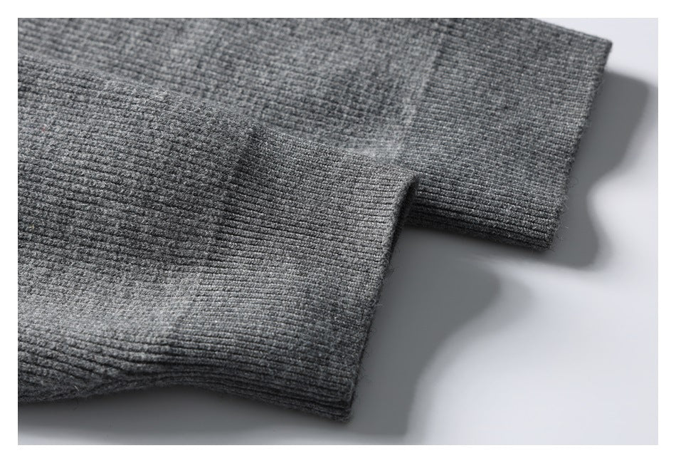 Close-up of two ribbed cuffs on a gray knit garment.