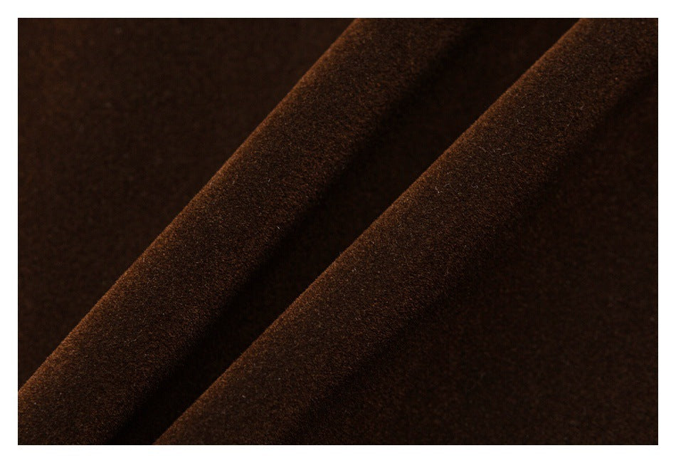 Close-up of dark brown fabric with a soft, napped surface and diagonal folds.