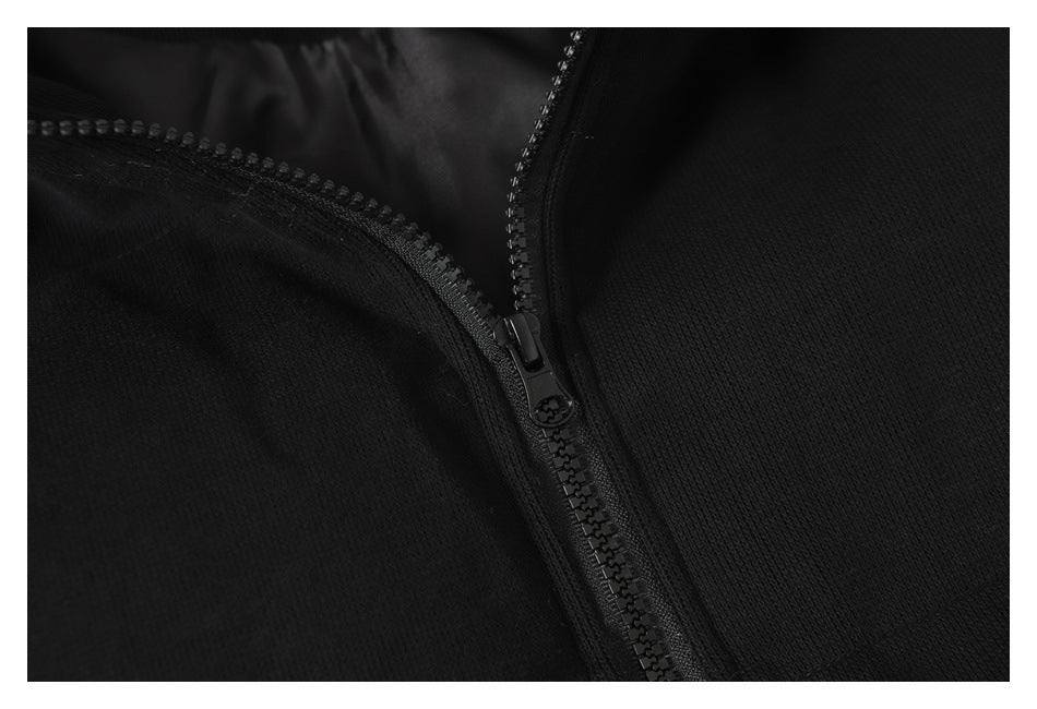Close-up of a black garment with a black front zipper and textured fabric.