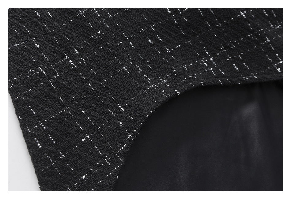 Close-up of black flecked fabric meeting a curved edge with dark lining visible beneath.